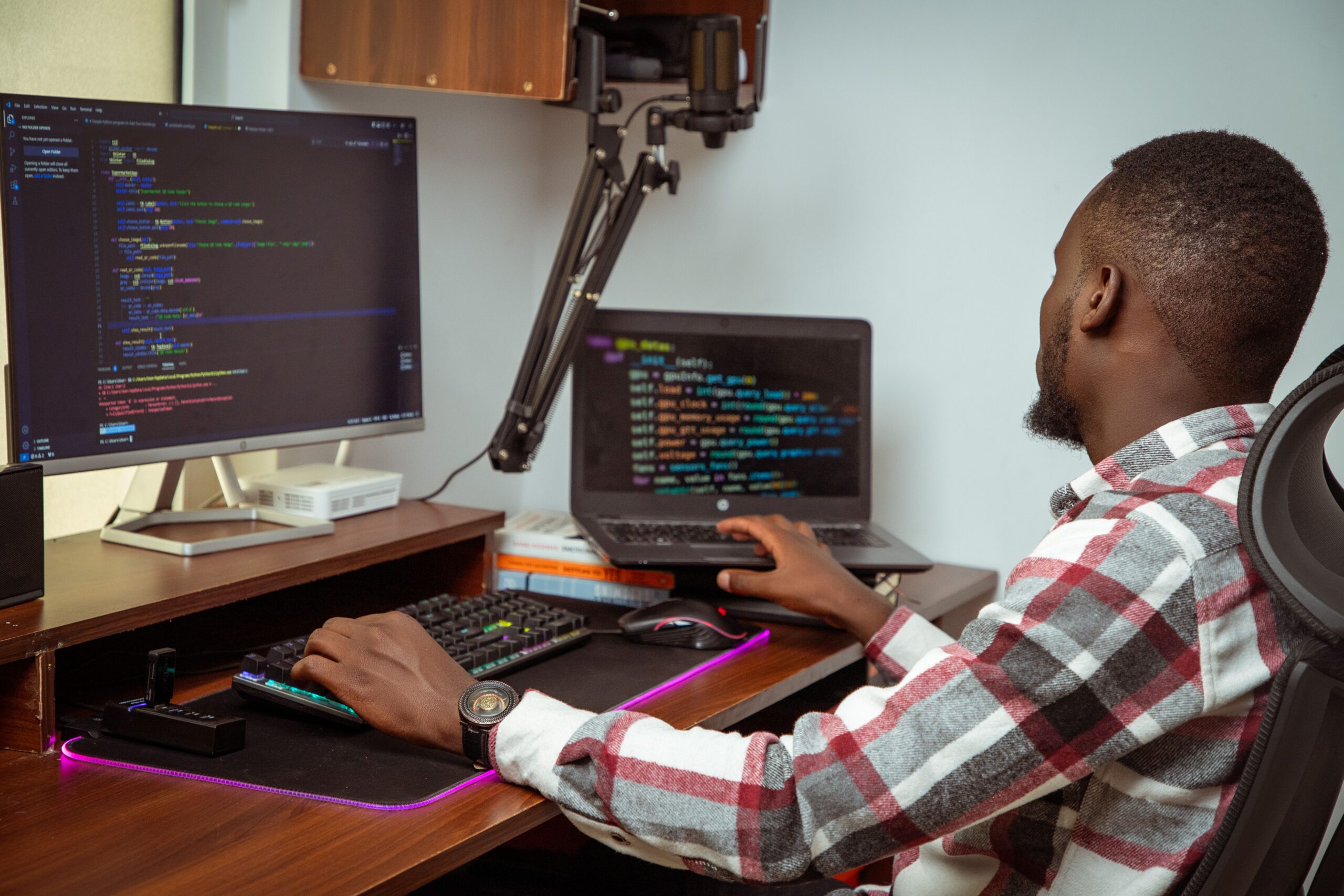 Homme africain codant sur ordinateur dans un bureau